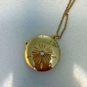 Gold starburst locket necklace.
